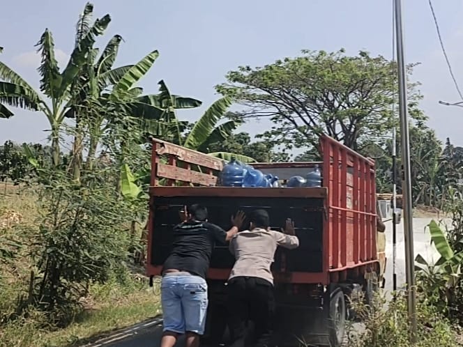 Anggota Polsek Bubulan Bersama Warga Masyarakat Bantu Dorong Mobil Mogok